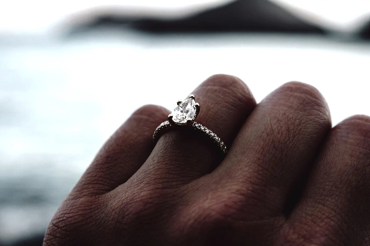 A pear cut engagement ring with a pav&eacute; band, small diamonds running along the shank